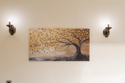 a painting of a tree on a wall with candles at Villa Aelia Luxury Maisonette in Salamís