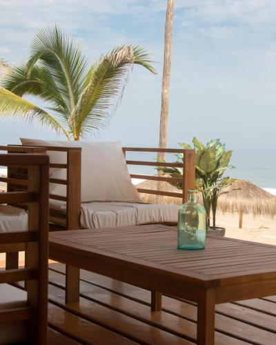 a wooden table with a glass bottle on top of a table at Hotel Gran Azul Bungalows in Canoas De Punta Sal