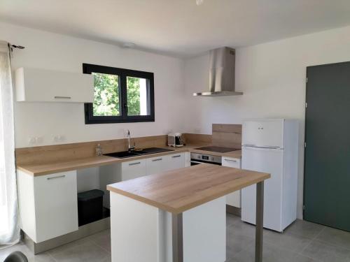 a kitchen with white cabinets and a wooden counter top at Maison de vacance in Luçon