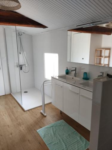 - une cuisine blanche avec un évier et une douche dans l'établissement Corps de ferme spacieux avec grand jardin, 10 personnes, à LʼAiguillon-sur-Vie