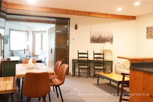 a living room with a table and a dining room at Escapade Pinoteau Tremblant Getaway in Mont-Tremblant