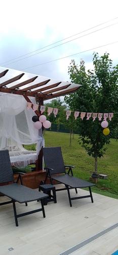 a group of chairs under a canopy with a tent at Smestaj sa bazenom Sunny Hill in Smederevska Palanka
