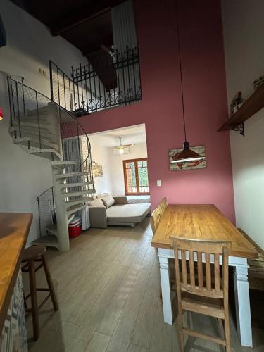 a living room with a table and chairs and a staircase at Novo Duplex em condomínio com piscina Juquehy in São Sebastião