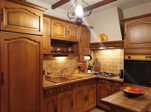 - une cuisine avec des placards en bois et un bol de fruits sur le comptoir dans l'établissement Le Mazet des oliviers, vue panoramique, à Saint-Hippolyte-du-Fort