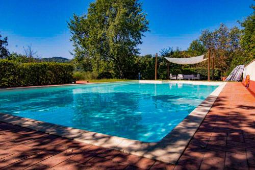 a swimming pool with blue water in a yard at Il Ginepro Home in Rosennano