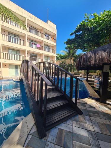 a bridge over a pool in front of a hotel at Pousada Recanto do Lobo in Porto De Galinhas