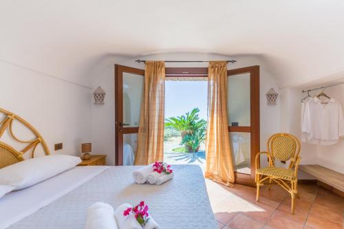 a bedroom with a bed and a large window at Dammuso Meraki in Pantelleria