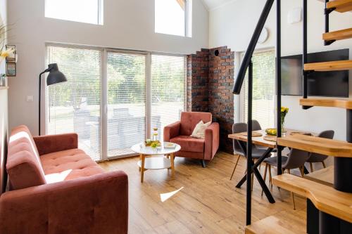a living room with two chairs and a table at Forrest Houses Bartosze in Bartosze