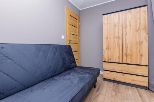 a bedroom with a bed and a wooden door at Forrest Houses Bartosze in Bartosze