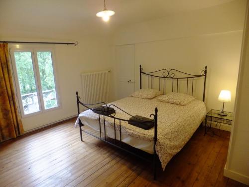 une chambre avec un lit et une fenêtre dans l'établissement La petite maison au bord de l'Orne, à Putanges