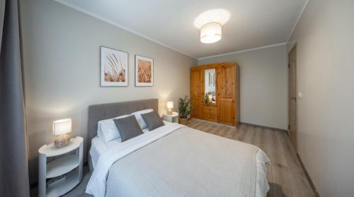 a bedroom with a large white bed and two lamps at City Park Quiet Residence - 2 Room Apartment with Balcony & View in Jūrmala