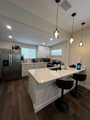 a kitchen with a refrigerator and a counter top at Steps to Trolley Stop 11 Renovated Home with Free EV Station in St. Augustine