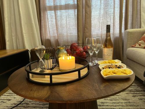 a table with a candle and wine glasses and wine bottles at Cozy retreat in Carlswald 264 in Midrand