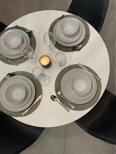 a white table with plates and wine glasses on it at Cozy retreat in Carlswald 264 in Midrand