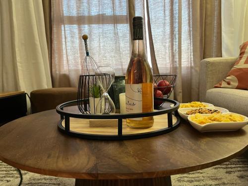 a table with a bottle of wine and a bowl of food at Cozy retreat in Carlswald 264 in Midrand