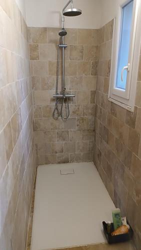 une douche carrelée avec un sol blanc et une fenêtre dans l'établissement Hébergement indépendant avec parking privé dans villa, à Grasse