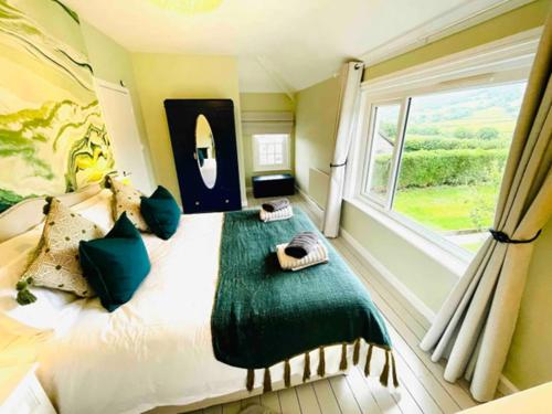 une chambre avec un grand lit avec une fenêtre dans l'établissement Awelfa a peaceful cottage in the Cambrian mountains, à Llanbrynmair