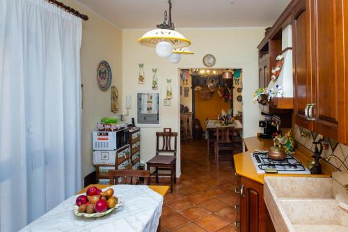 a kitchen with a table with a bowl of fruit on it at B&B Villa Liliya in Fiumefreddo di Sicilia
