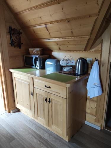 a kitchen with a stove and a microwave at B&R Pokoje Gościnne in Ząb