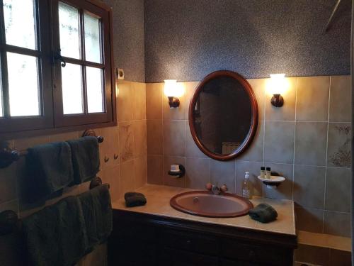 une salle de bain avec un lavabo et un miroir dans l'établissement Le Mazet des oliviers, vue panoramique, à Saint-Hippolyte-du-Fort