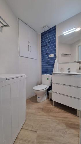 a white bathroom with a toilet and a sink at Diana Playa in Benalmádena