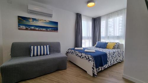 a bedroom with a bed and a chair at Diana Playa in Benalmádena