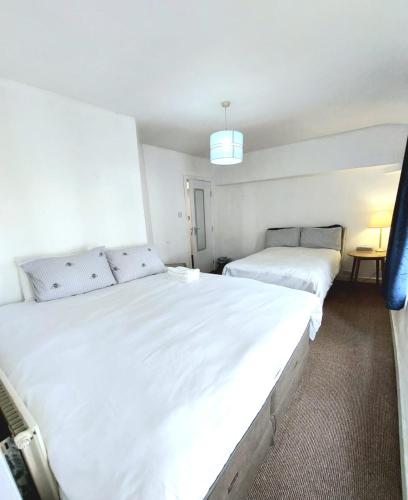 two beds in a room with white sheets at Liverpool Newington Stay in Liverpool