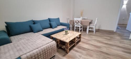 クマノヴォにあるOld House Apartmentの青いソファとテーブルのあるリビングルーム