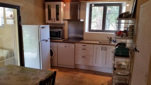 une cuisine avec un réfrigérateur blanc et une fenêtre dans l'établissement La Bastide des Muriers, à Gargas