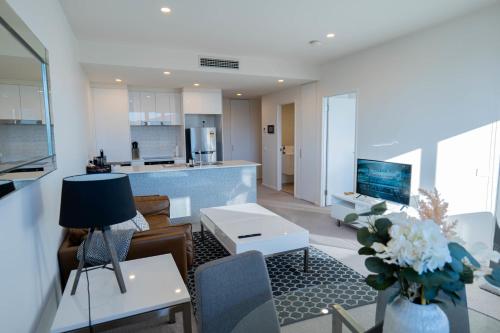 a living room with a couch and a kitchen at Braddon Abode - Canberra in Canberra