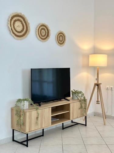 a flat screen tv sitting on top of a wooden entertainment center at Casa d' Irene fully equipped House in Koufonisia