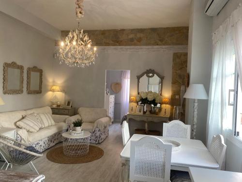 a living room with a couch and a chandelier at Casita Boutique en la playa in Sant Antoni de Calonge