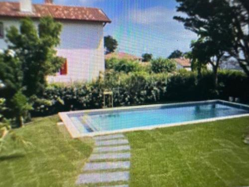 een zwembad in een tuin naast een huis bij Argizaria in Ciboure
