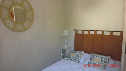 une chambre avec un lit et un miroir au mur dans l'établissement domino, à Saint-Georges-dʼOléron