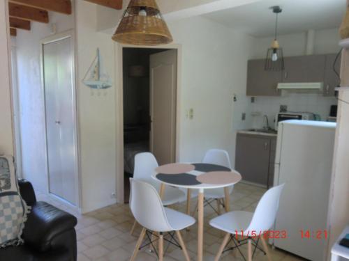 une cuisine avec une table et des chaises dans une pièce dans l'établissement domino, à Saint-Georges-dʼOléron