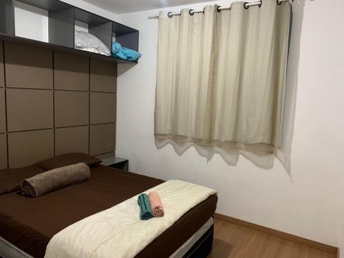 a small bedroom with two beds and a window at Millennium Residence in Juiz de Fora