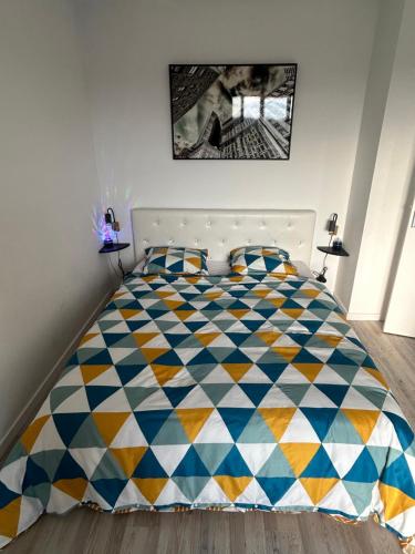 - une chambre avec un lit bleu et jaune dans l'établissement Appartement, à Montceau-les-Mines