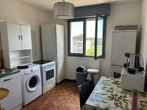une cuisine avec une machine à laver et une fenêtre dans l'établissement Appartement, à Montceau-les-Mines
