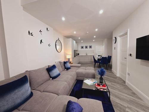 a living room with a couch and a table at Abbey Corner by Nivaas 3-Located in the heart of the city centre-5 minute walk to train station-20 minutes to London via train in Reading
