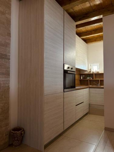 a kitchen with wooden cabinets and a microwave at Lake house Zoya in Nikšić