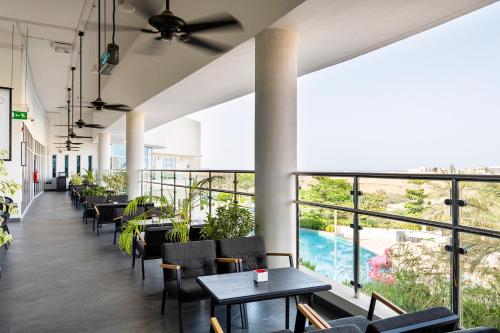 a restaurant with tables and chairs and a view of a pool at Crowne Plaza Muscat OCEC by IHG in Muscat