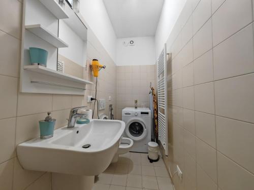 a bathroom with a sink and a washing machine at Goldmine Guest House 1 in Venice