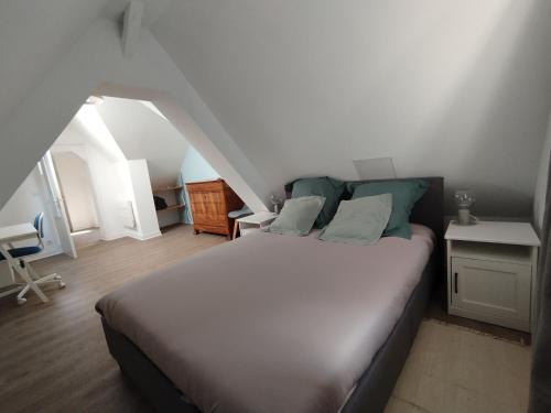 une chambre avec un grand lit dans un grenier dans l'établissement Duplex en centre-ville, à Morlaix