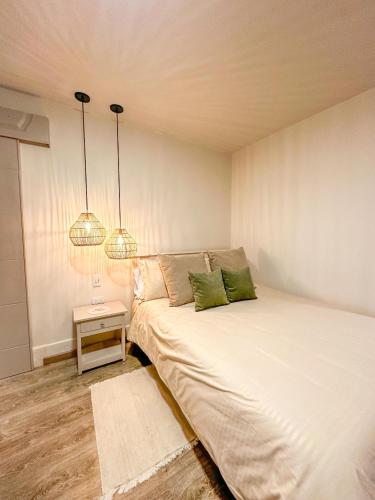 a bedroom with two beds and two lamps at Hotel Posada de Santa Elena in Tunja