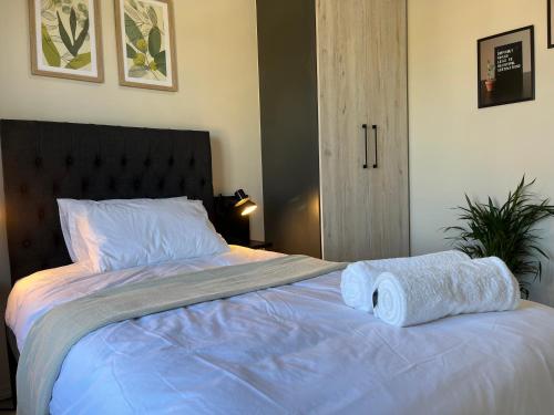 a bedroom with a bed with two towels on it at Cozy retreat in Carlswald 264 in Midrand