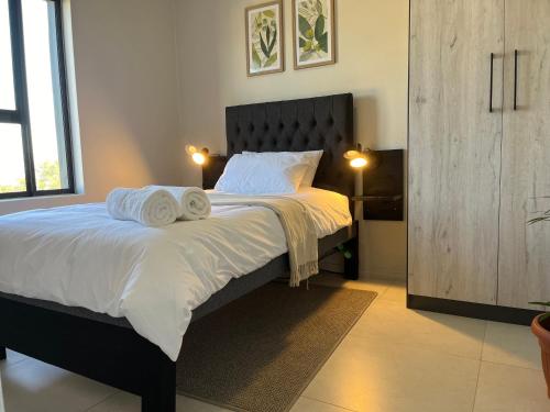 a bedroom with a large bed with towels on it at Cozy retreat in Carlswald 264 in Midrand