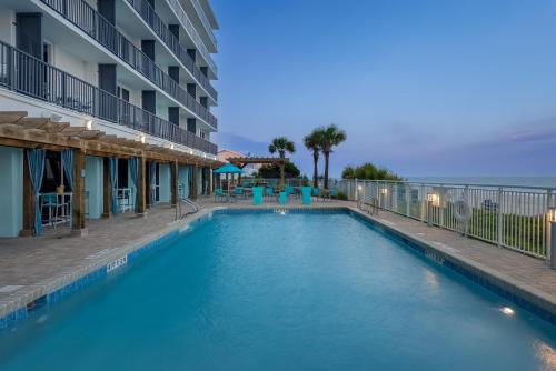 a swimming pool in front of a hotel with the ocean at Holiday Inn Resort Oceanfront at Surfside Beach by IHG in Myrtle Beach