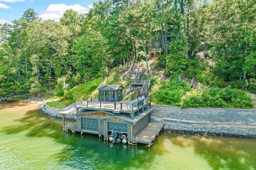 a house on a dock in the middle of the water at Water's Edge Holmstead in Lake Lure
