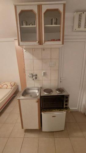 a small kitchen with a sink and a microwave at Apartments Bojanic in Bar