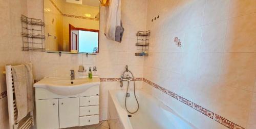 a bathroom with a sink and a bath tub at Apartmán Bulvár in Žilina